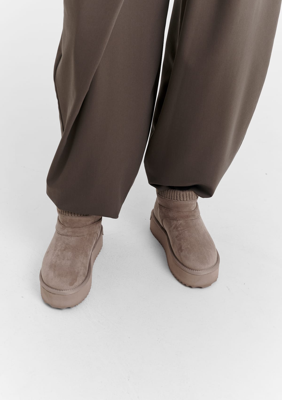 Tragebild mit Model auf neutralem Hintergrund des Produktes Cozy Mid in der Farbe Mocha