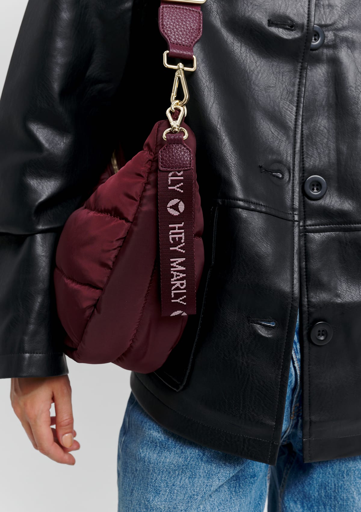 Tragebild mit Model auf neutralem Hintergrund des Produktes Signature Keyholder in der Farbe Berry