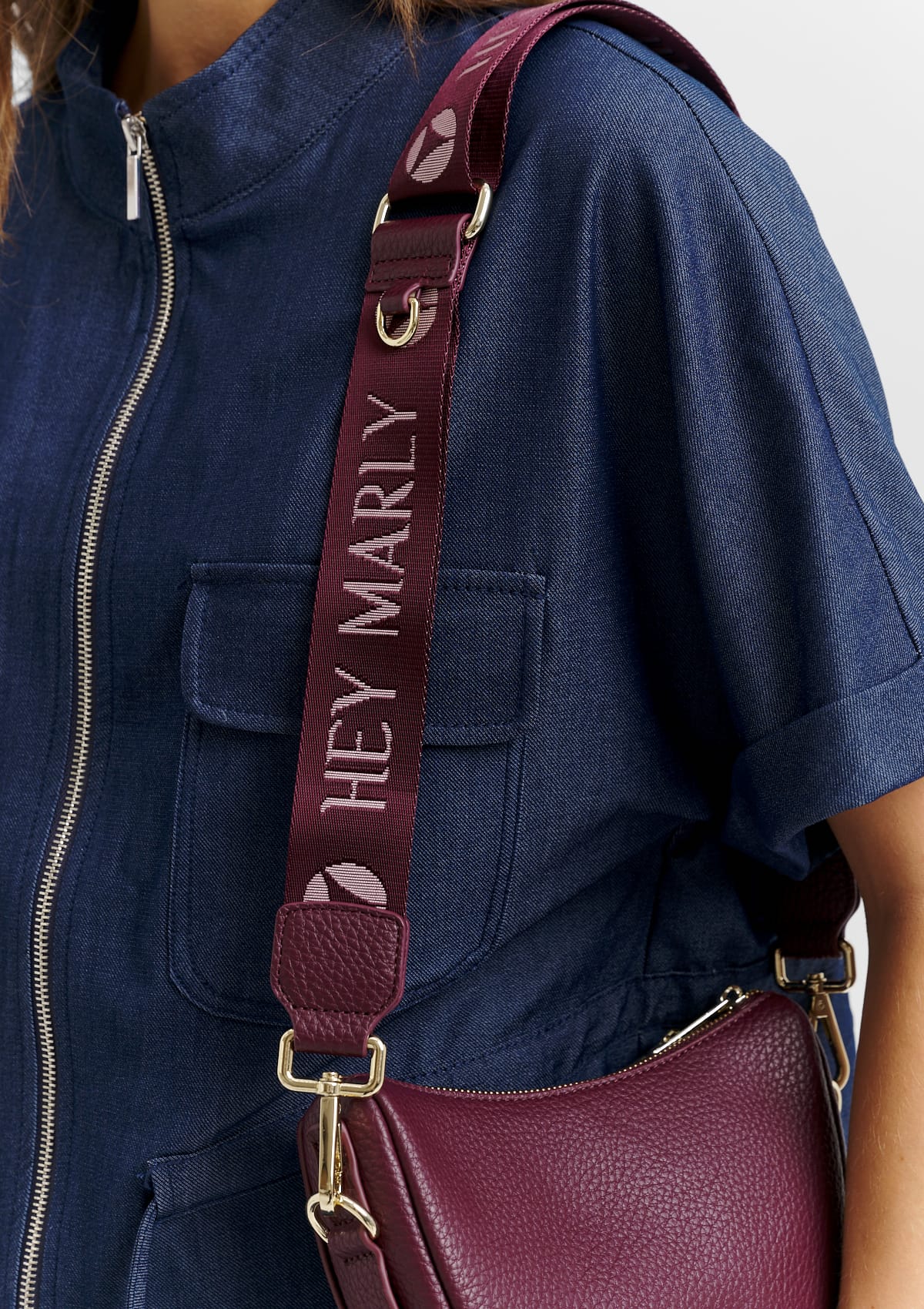 Tragebild mit Model auf neutralem Hintergrund des Produktes Signature Strap in der Farbe Berry