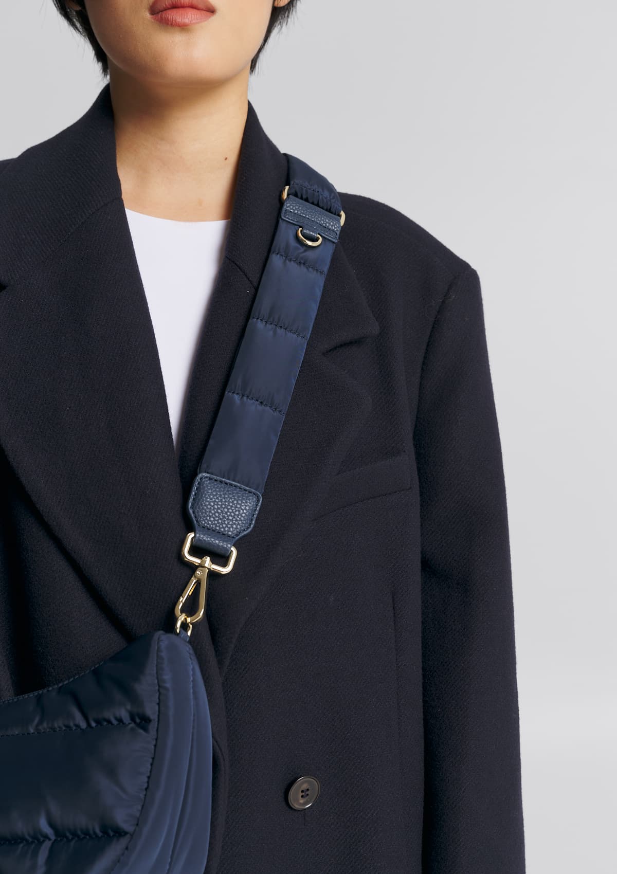 Tragebild mit Model auf neutralem Hintergrund des Produktes Puffy Nylon Strap in der Farbe Deep Blue