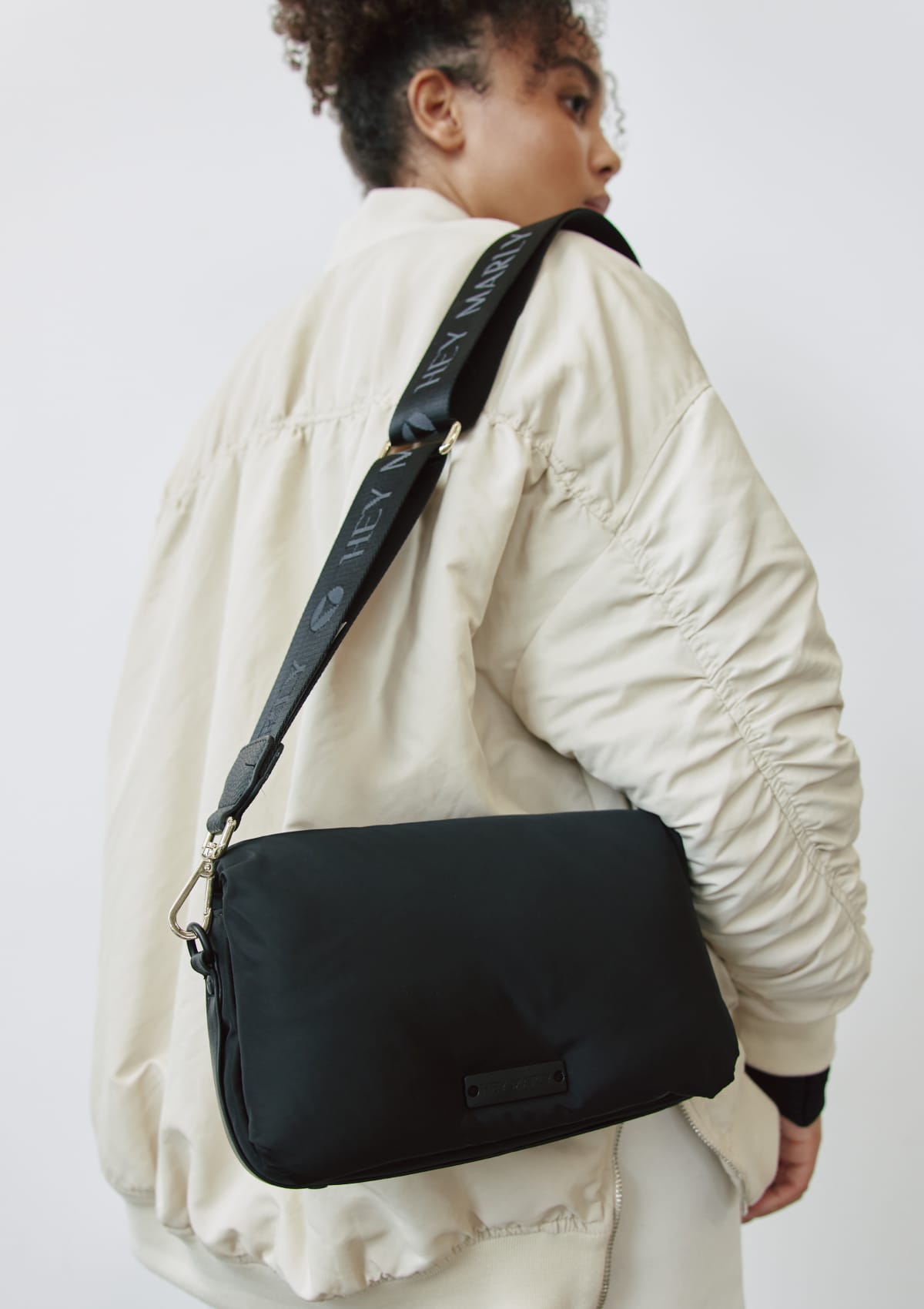 Tragebild mit Model auf neutralem Hintergrund des Produktes Signature Strap in der Farbe Black