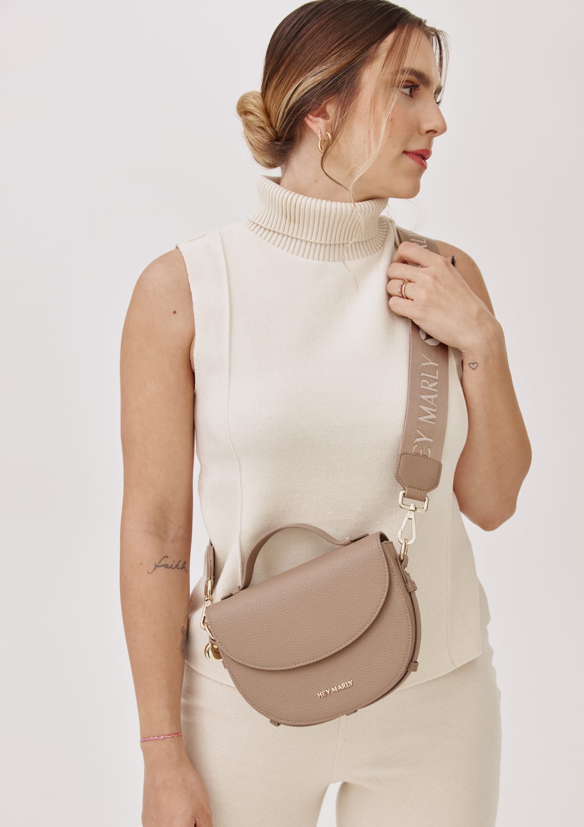 Tragebild mit Model auf neutralem Hintergrund des Produktes Signature Strap in der Farbe Mocha