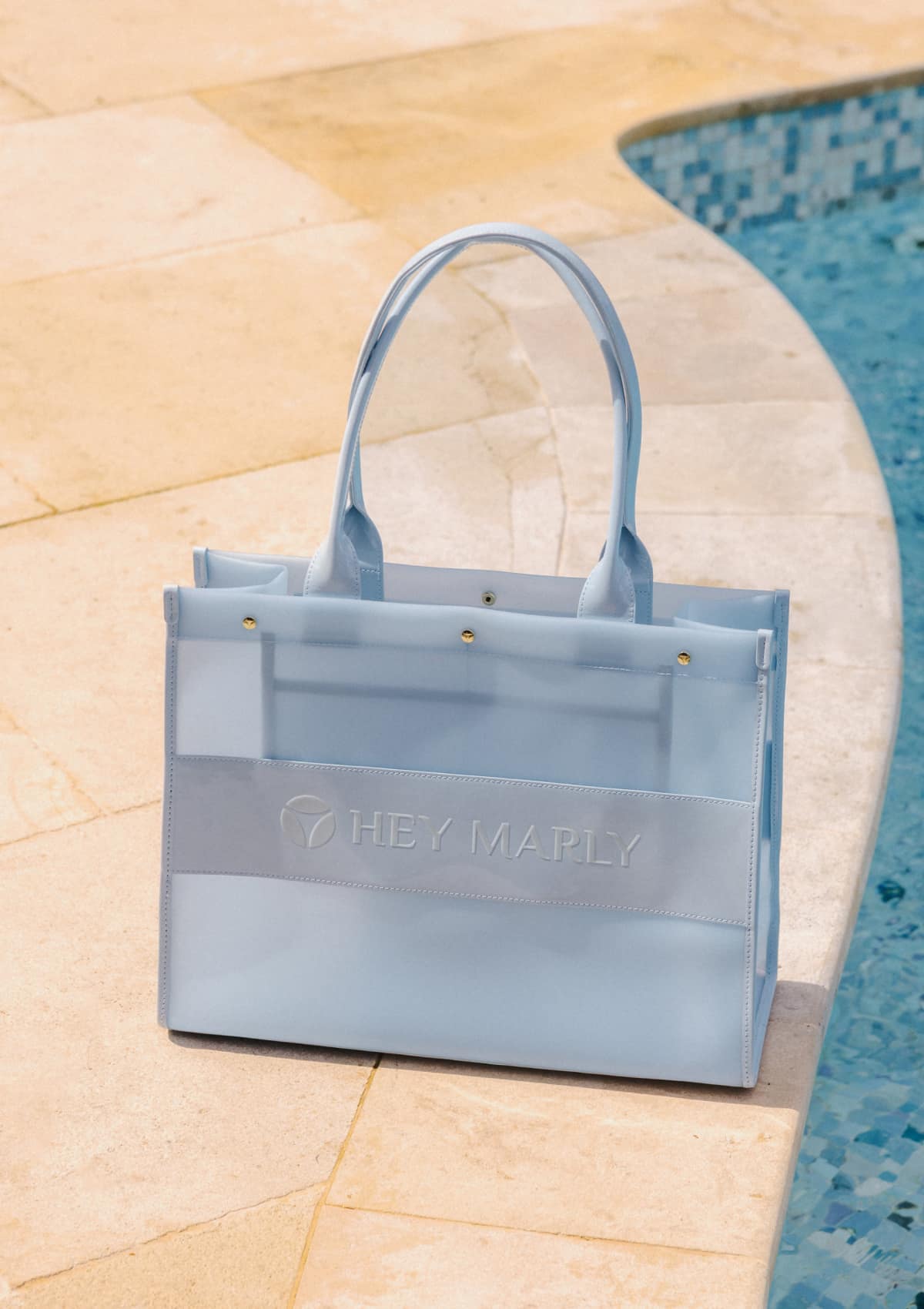 Tragebild mit Model auf neutralem Hintergrund des Produktes Transparent Signature Bag in der Farbe Blue Light