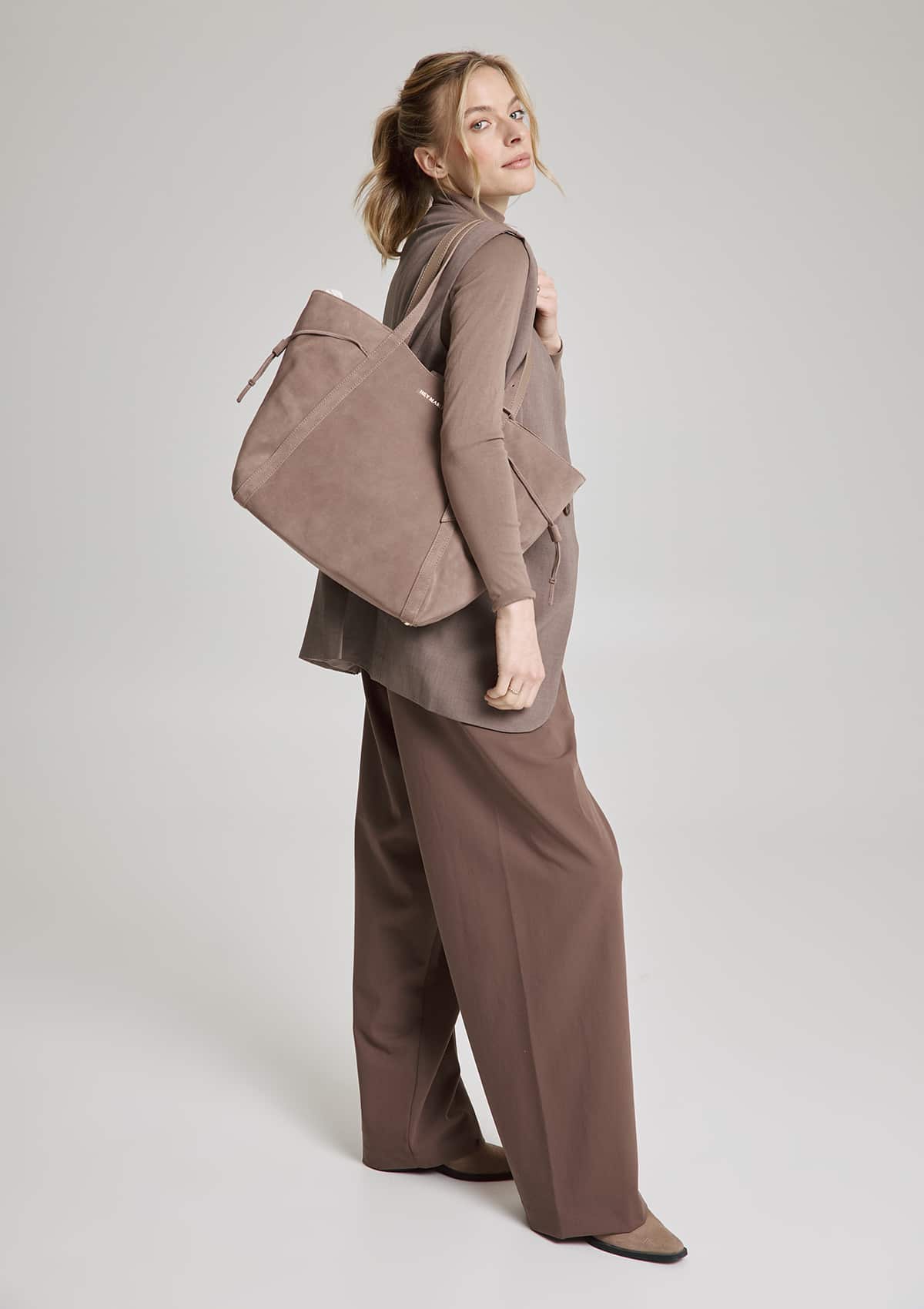 Tragebild mit Model auf neutralem Hintergrund des Produktes Pretty Wonder Suede M in der Farbe Mocha in der Größe M