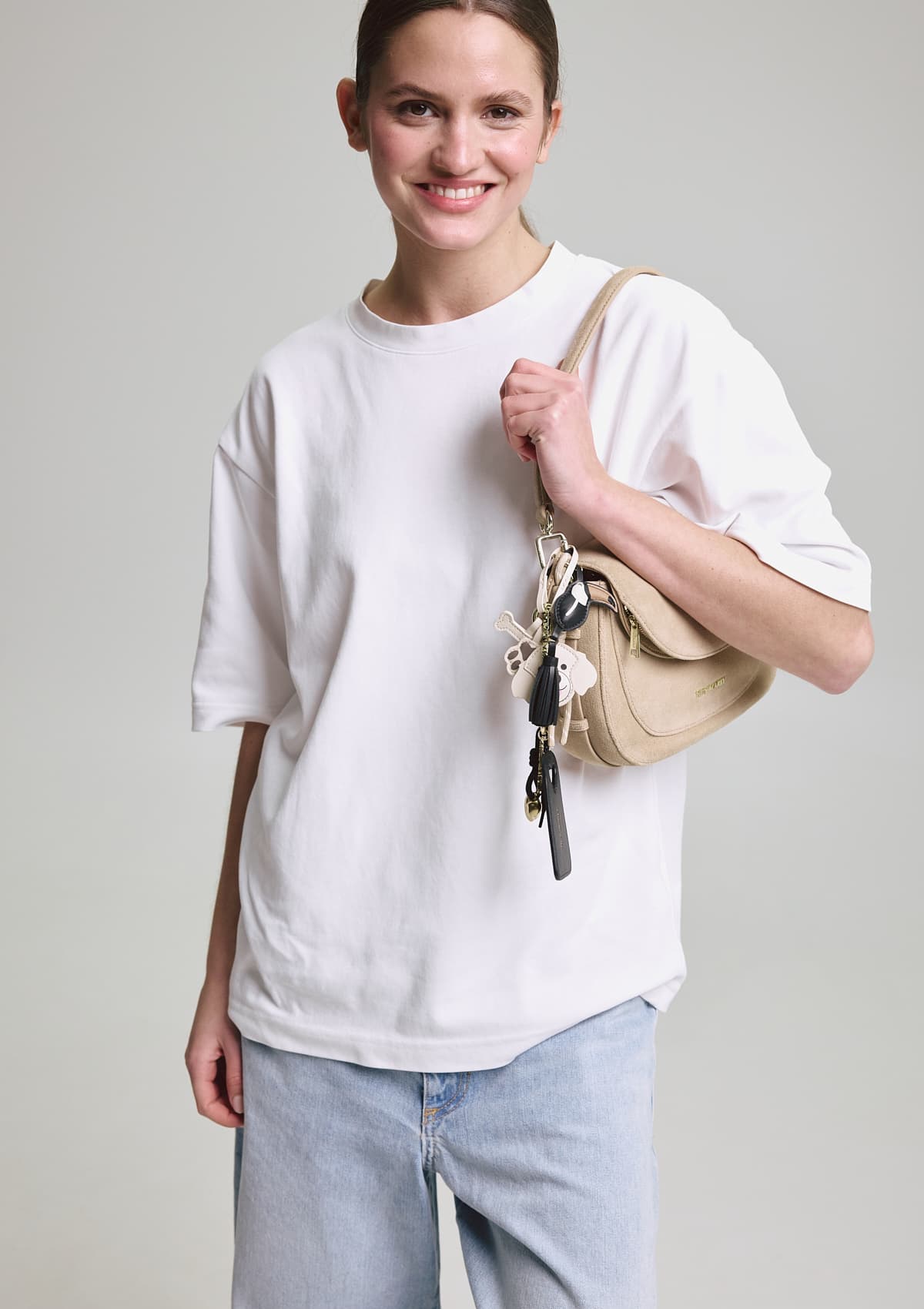 Tragebild mit Model auf neutralem Hintergrund des Produktes Dog Charm in der Farbe Crema