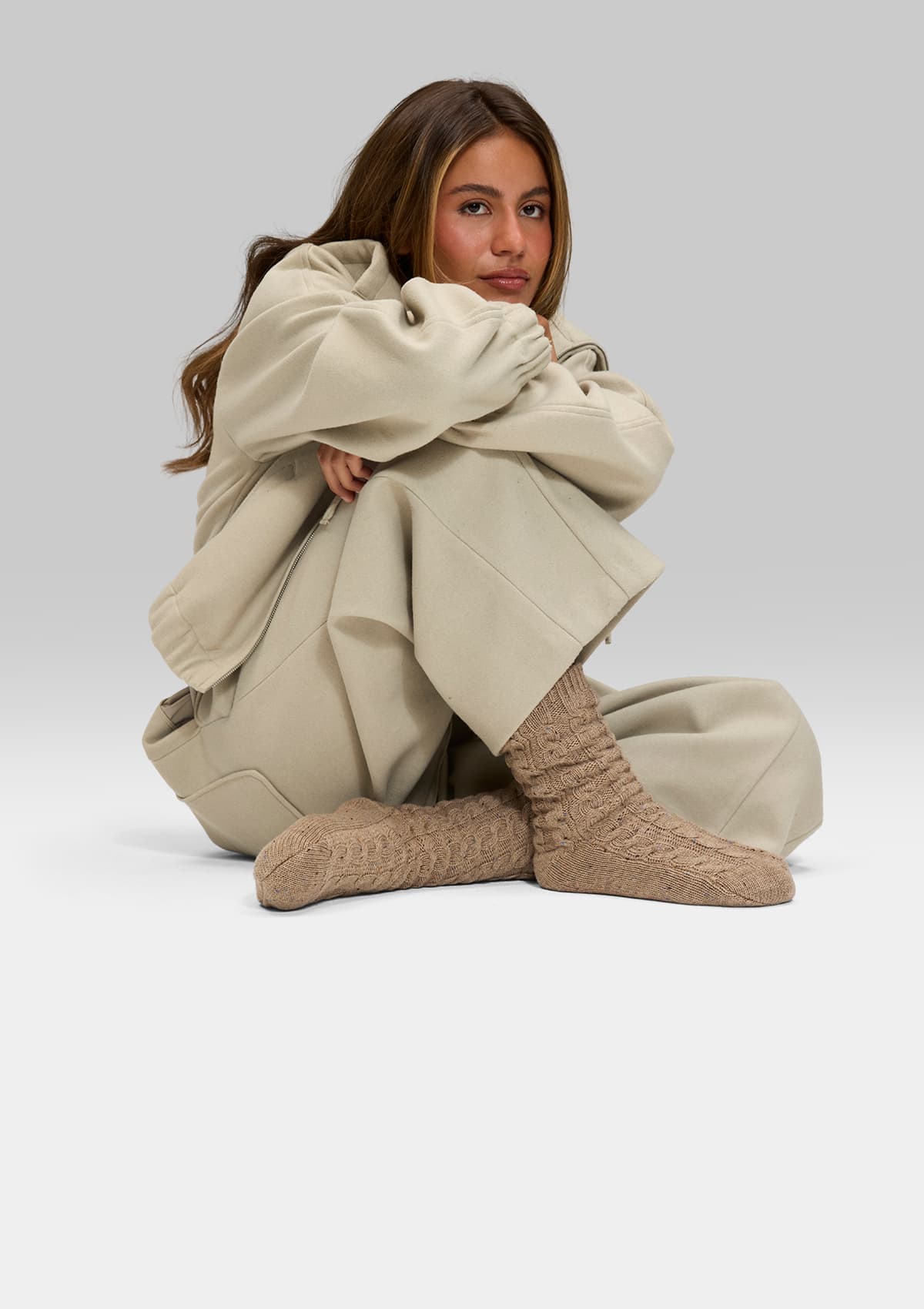 Tragebild mit Model auf neutralem Hintergrund des Produktes Cozy Home Socks in der Farbe Mocha
