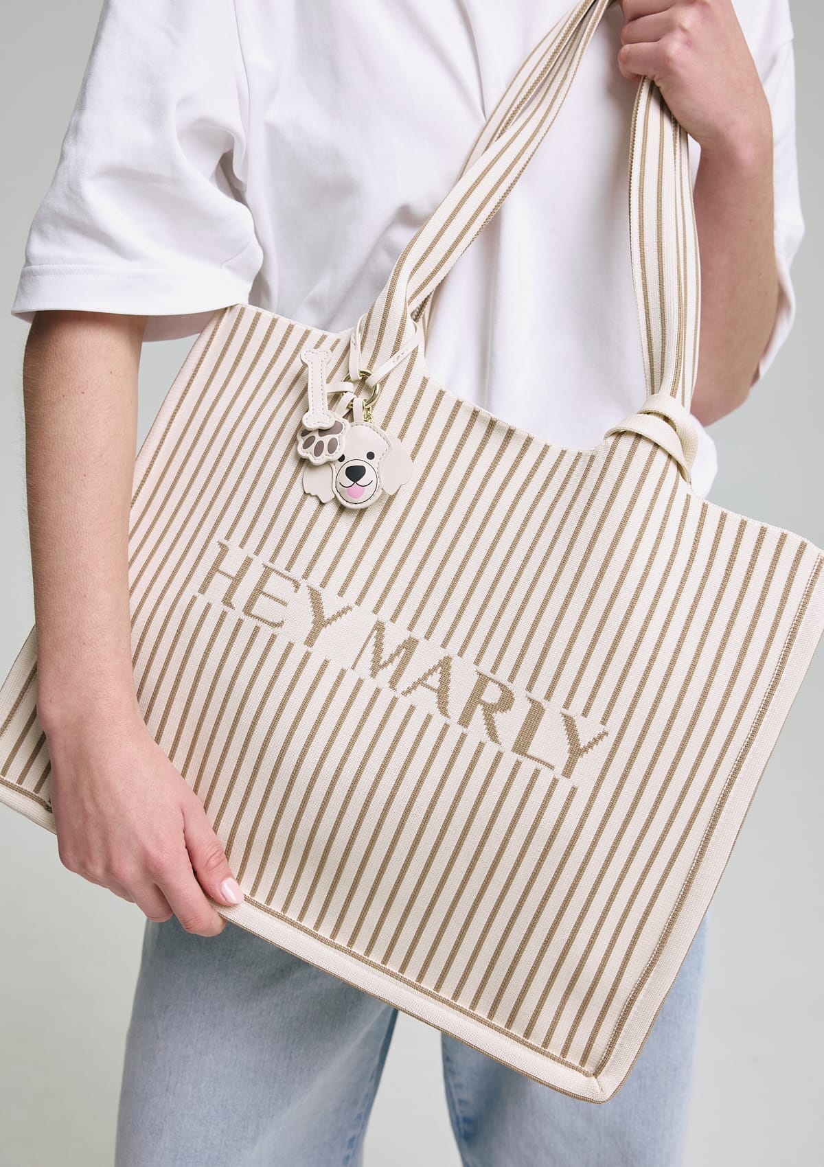 Tragebild mit Model auf neutralem Hintergrund des Produktes Casual Signature Bag in der Farbe Crema-Sand
