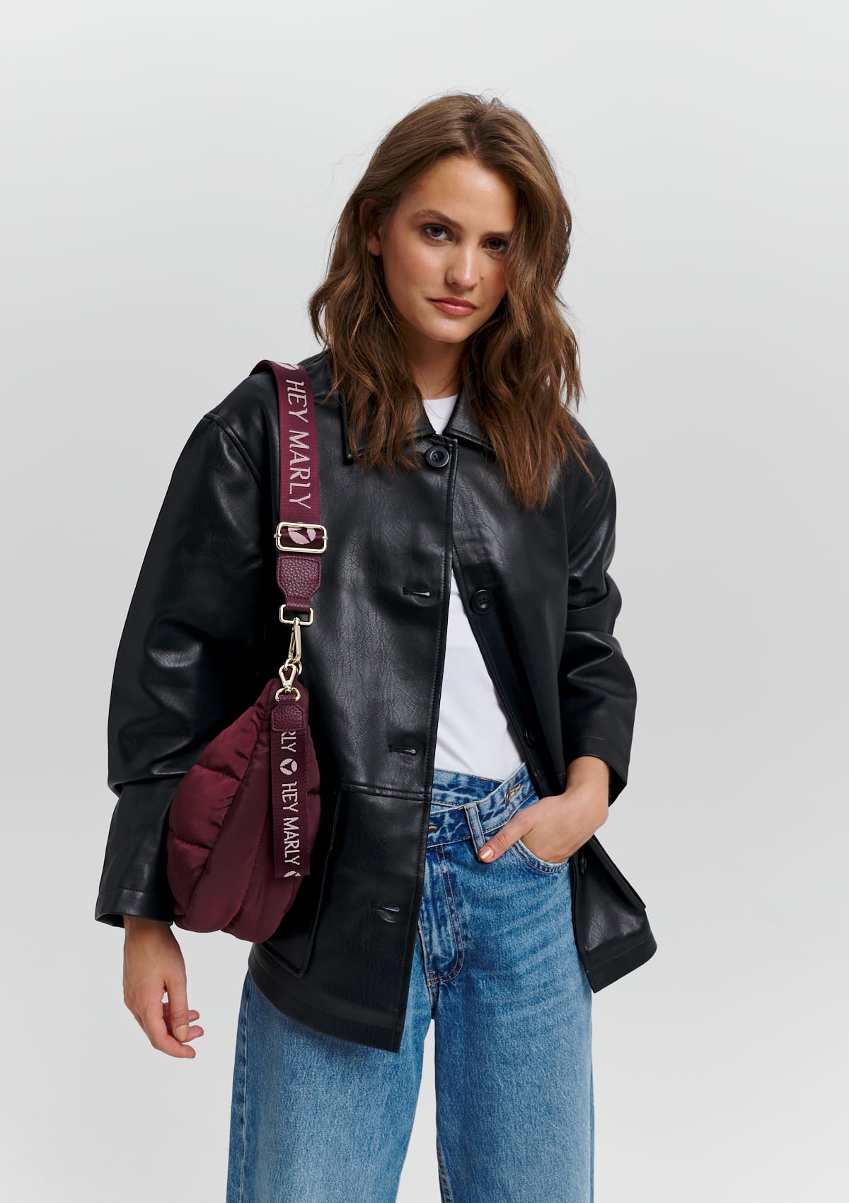 Tragebild mit Model auf neutralem Hintergrund des Produktes Signature Keyholder in der Farbe Berry