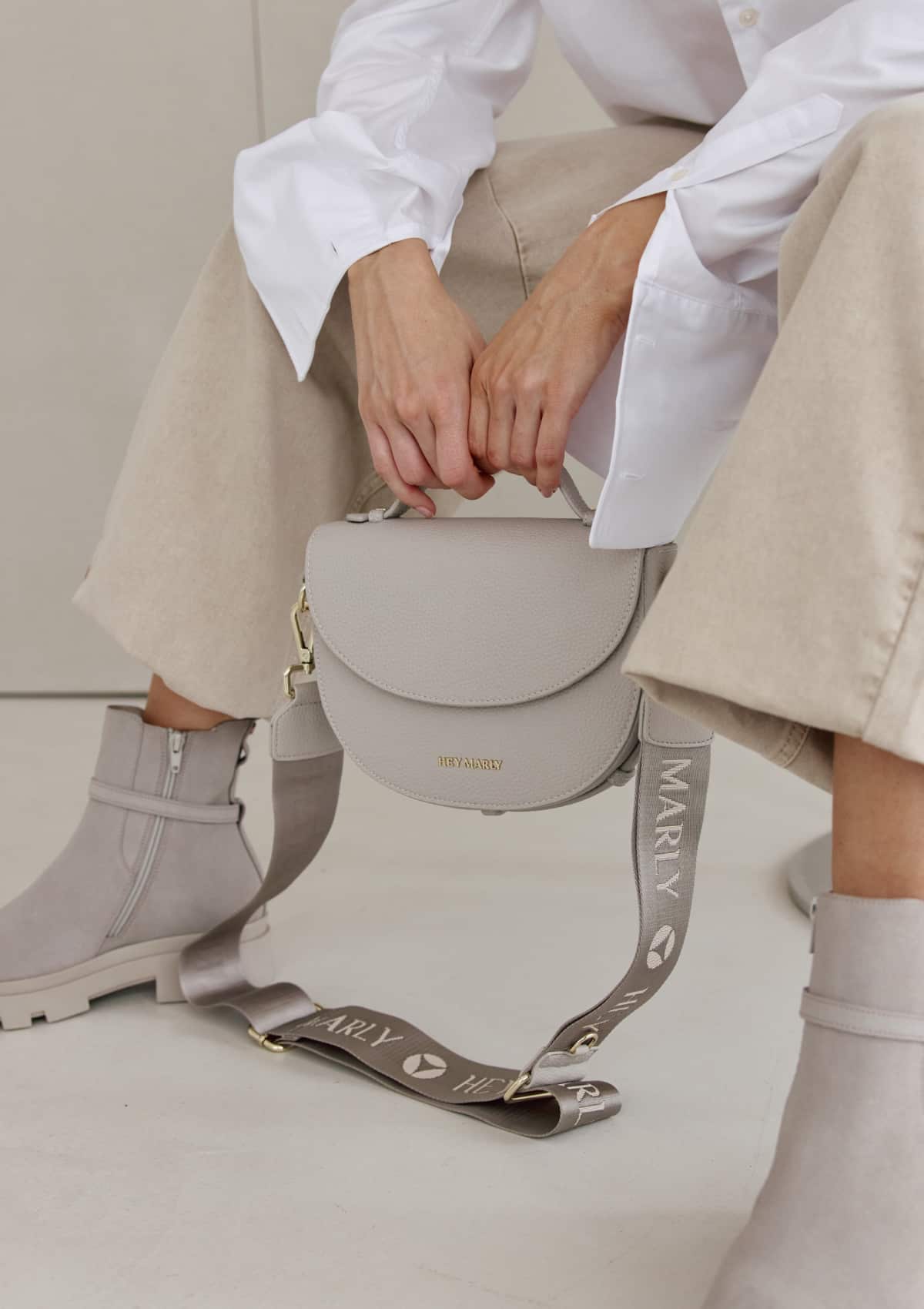 Tragebild mit Model auf neutralem Hintergrund des Produktes Signature Strap in der Farbe Greige