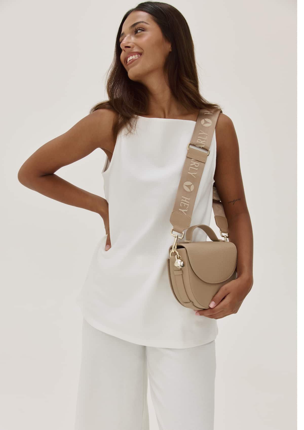 Tragebild mit Model auf neutralem Hintergrund des Produktes Signature Strap in der Farbe Sand