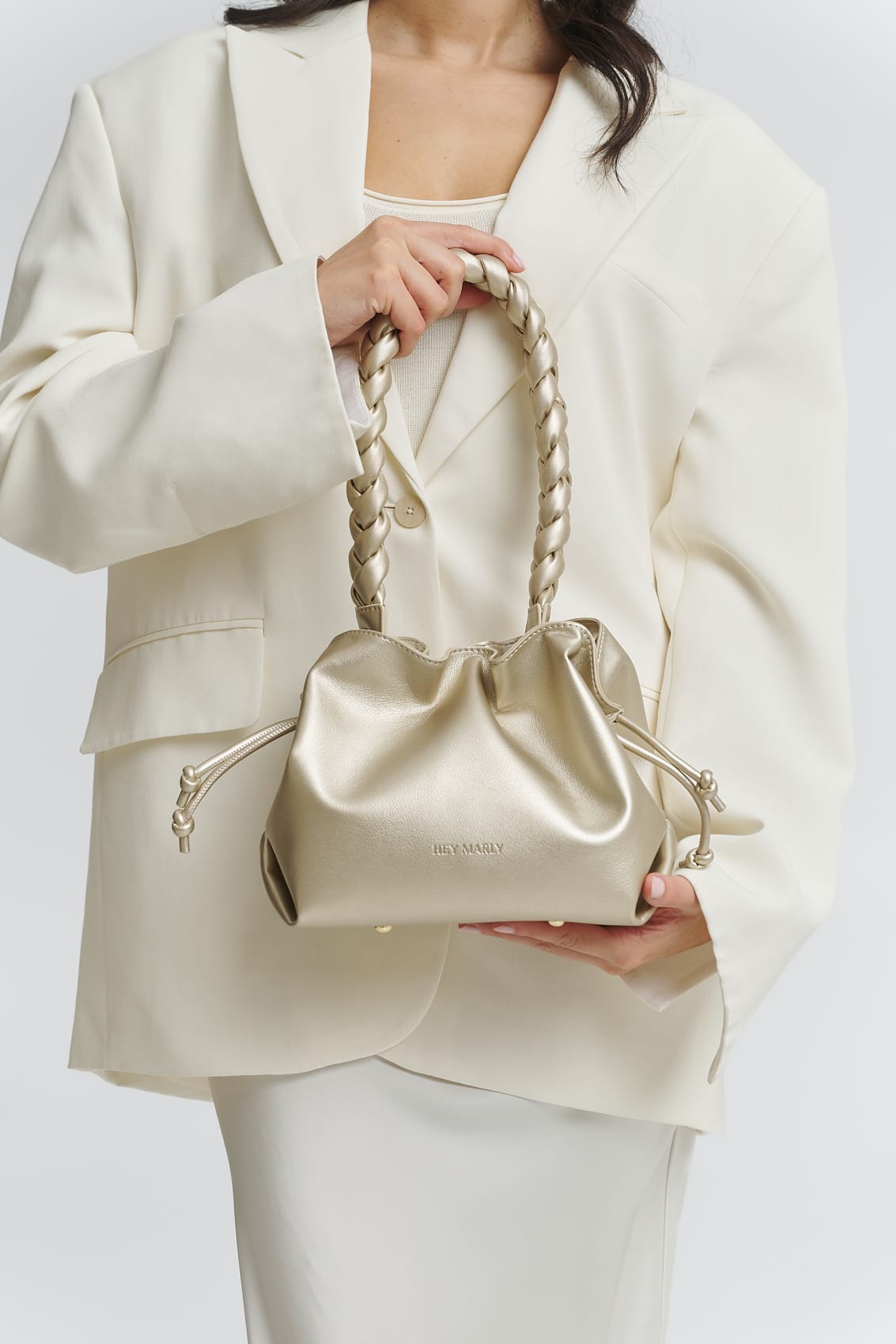 Tragebild mit Model auf neutralem Hintergrund des Produktes Braided Strap in der Farbe Gold