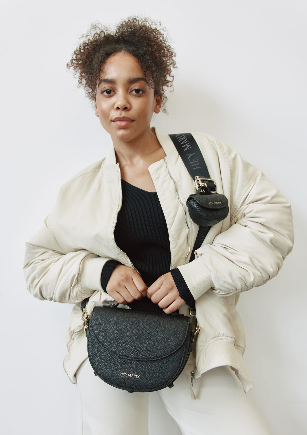 Tragebild mit Model auf neutralem Hintergrund des Produktes Signature Strap in der Farbe Black
