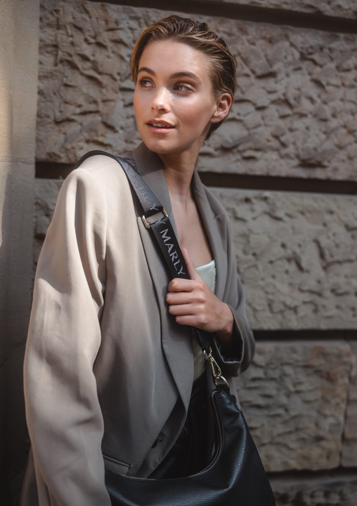 Tragebild mit Model auf neutralem Hintergrund des Produktes Signature Strap in der Farbe Black