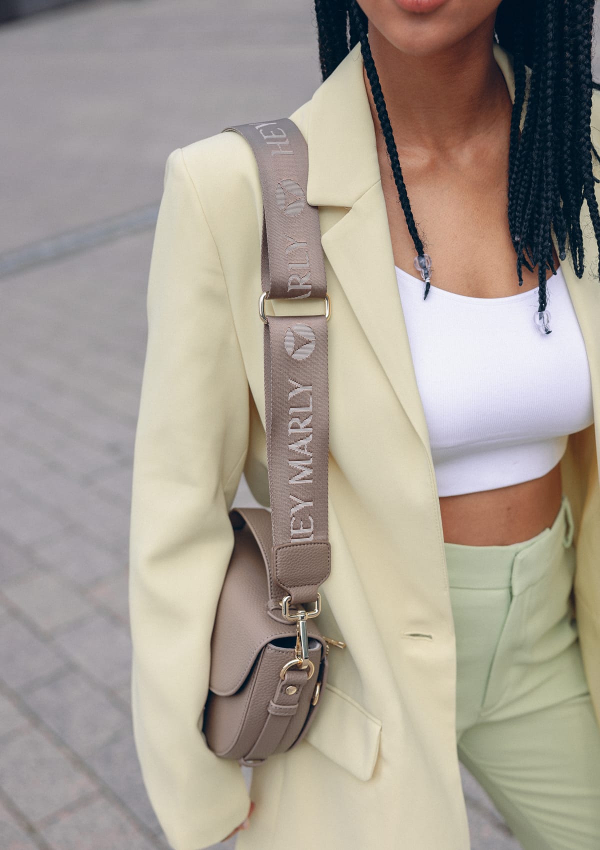 Tragebild mit Model auf neutralem Hintergrund des Produktes Signature Strap in der Farbe Mocha