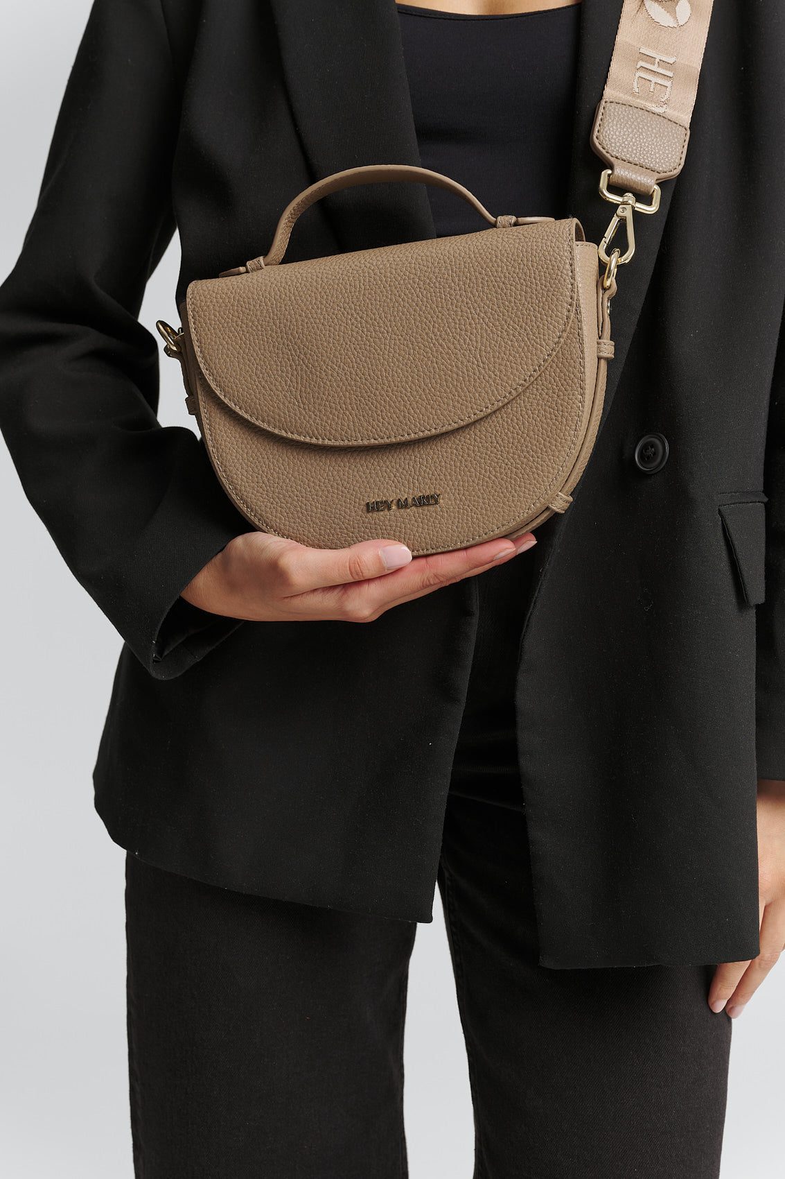 Tragebild mit Model auf neutralem Hintergrund des Produktes Signature Strap in der Farbe Mocha