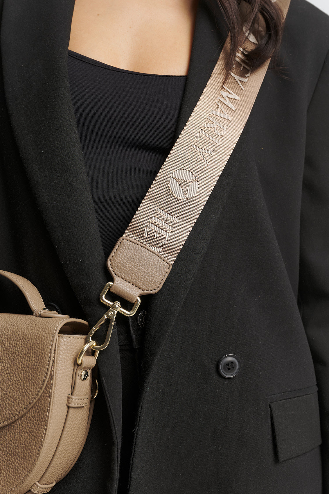Tragebild mit Model auf neutralem Hintergrund des Produktes Signature Strap in der Farbe Mocha