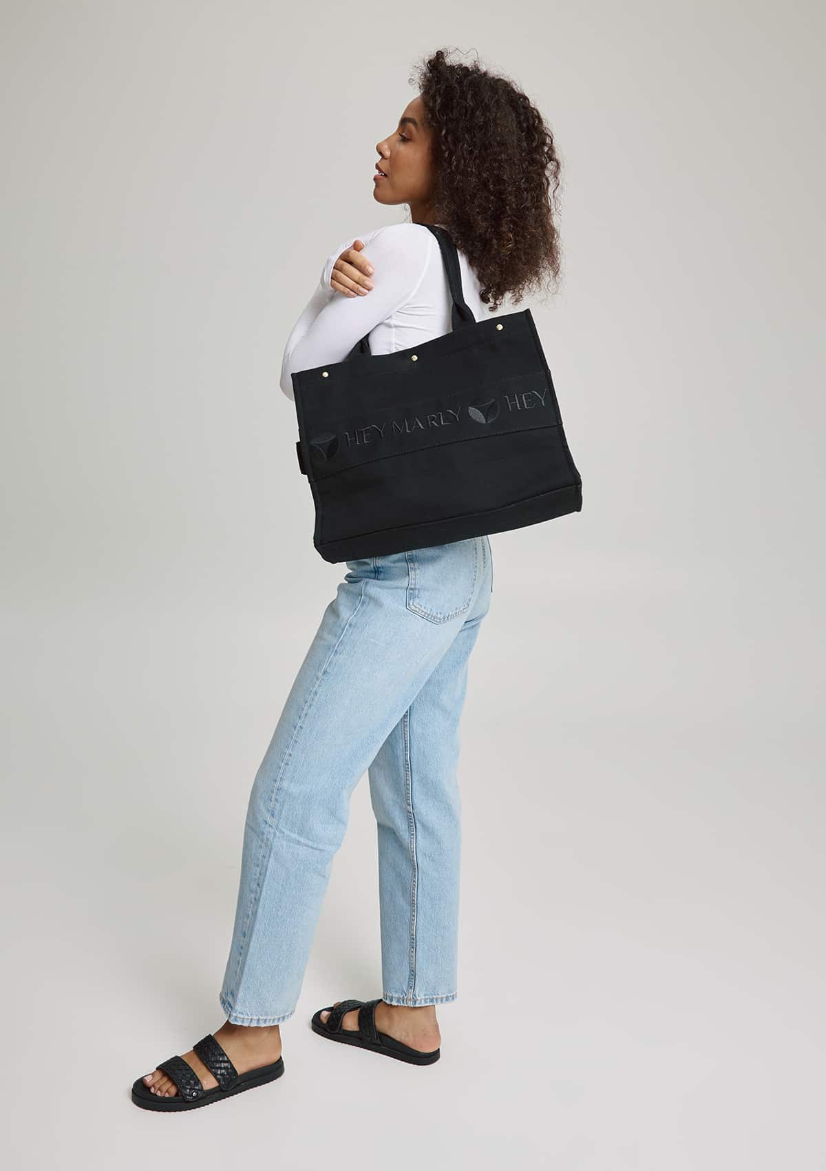 Tragebild mit Model auf neutralem Hintergrund des Produktes Signature Bag in der Farbe Black