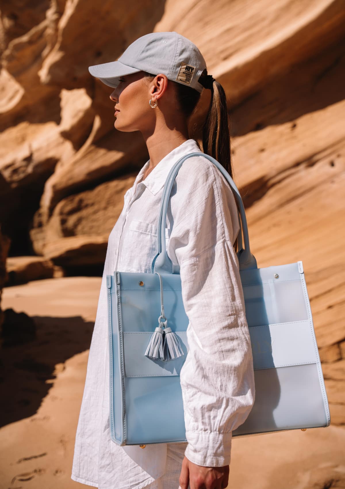 Tragebild mit Model auf neutralem Hintergrund des Produktes Transparent Signature Bag in der Farbe Blue Light