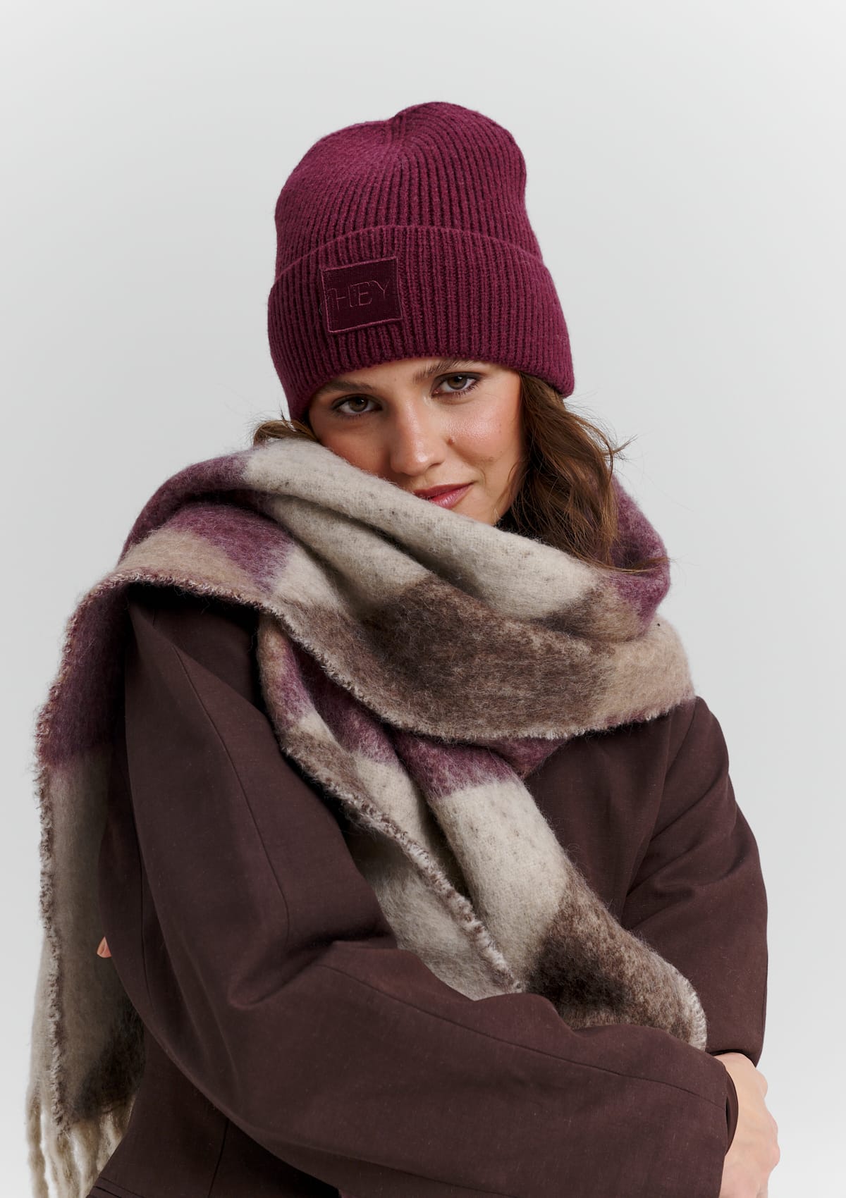 Tragebild mit Model auf neutralem Hintergrund des Produktes Cozy Scarf in der Farbe Berry