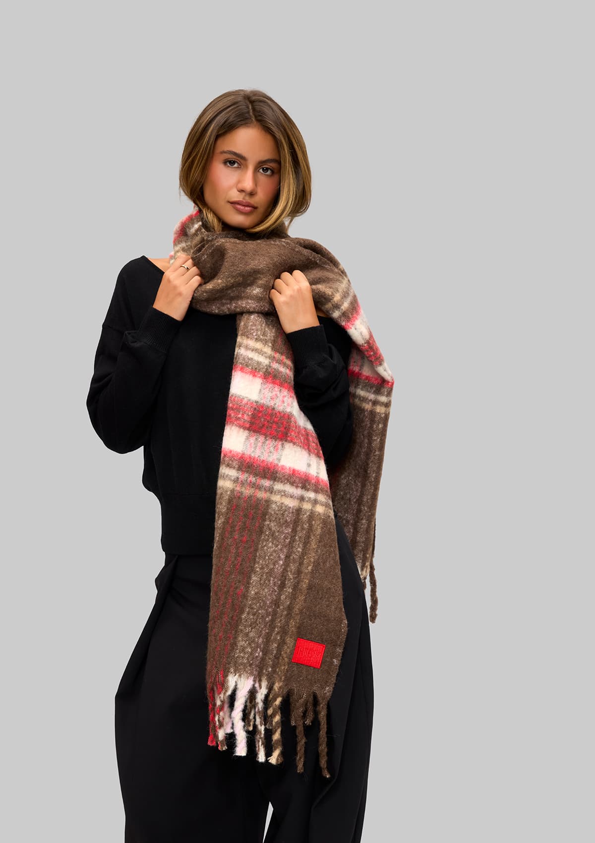 Tragebild mit Model auf neutralem Hintergrund des Produktes Check Scarf in der Farbe Coffee